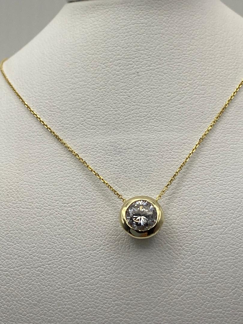 1 carat round brilliant solitaire bezel set solitaire in 14K solid yellow gold.