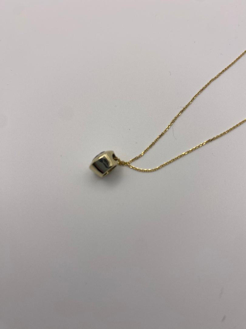 1 carat round brilliant solitaire bezel set solitaire in 14K solid yellow gold.