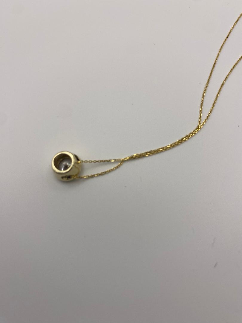 1 carat round brilliant solitaire bezel set solitaire in 14K solid yellow gold.