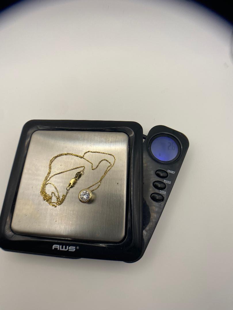 1 carat round brilliant solitaire bezel set solitaire in 14K solid yellow gold.
