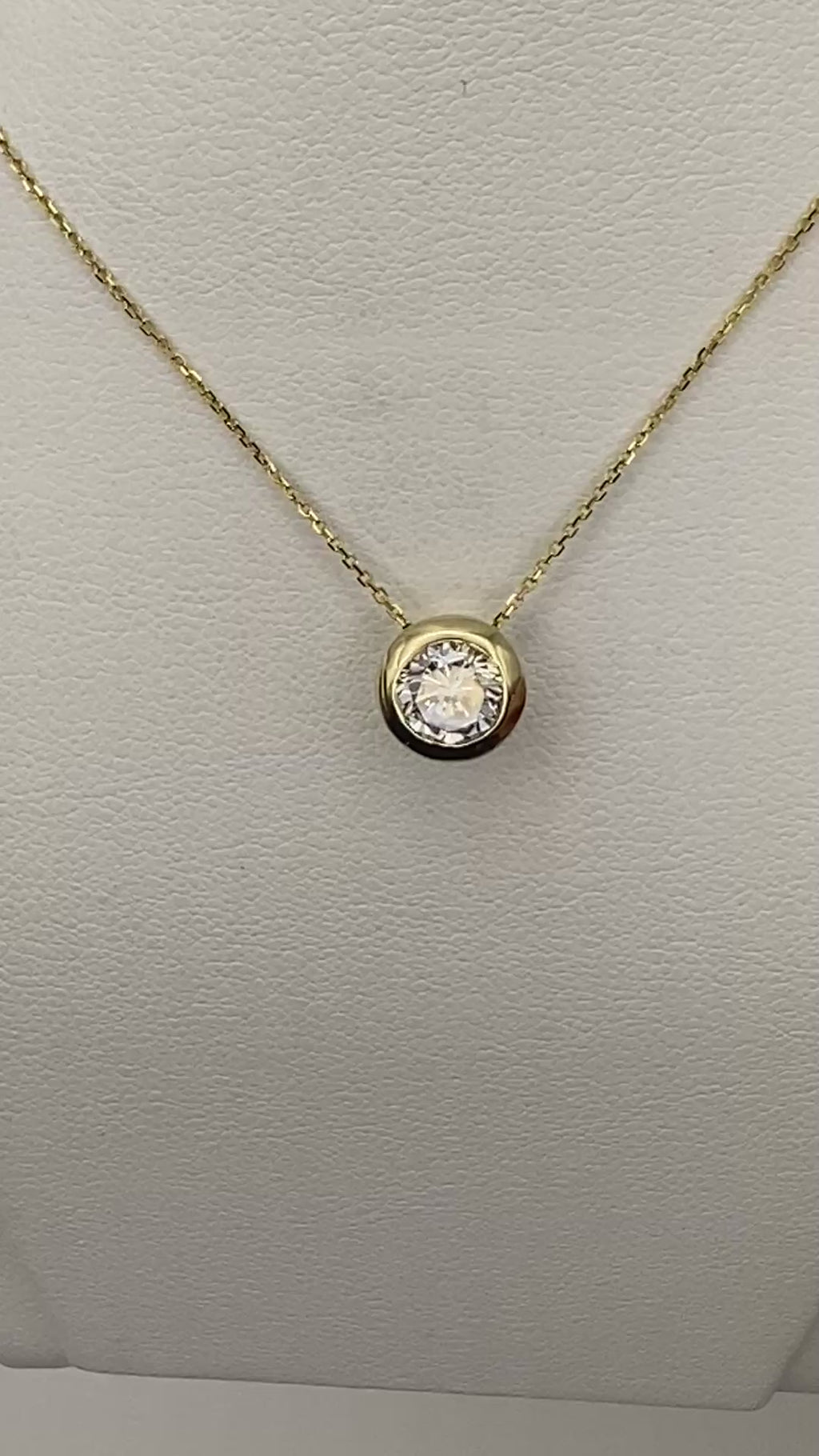 1 carat round brilliant solitaire bezel set solitaire in 14K solid yellow gold.