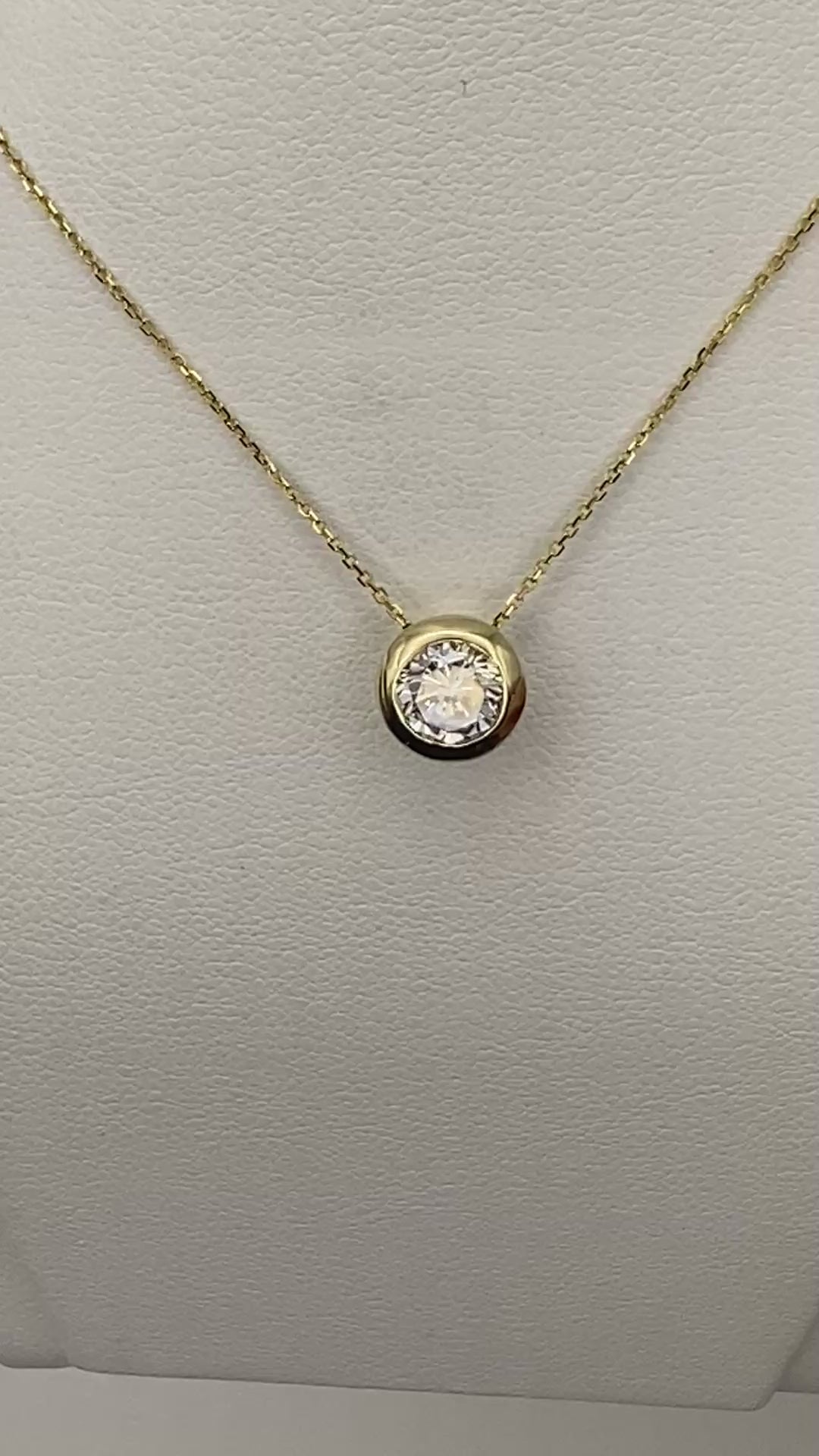 1 carat round brilliant solitaire bezel set solitaire in 14K solid yellow gold.
